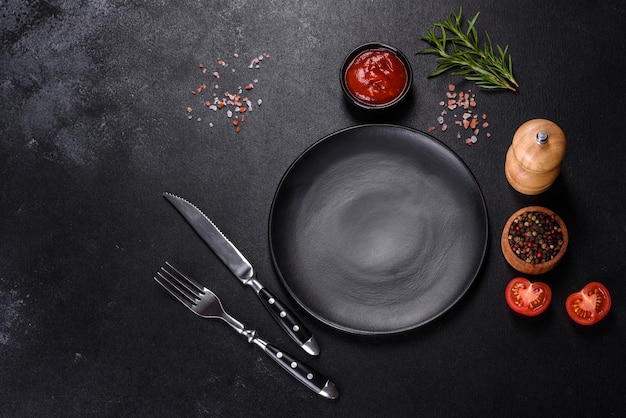 Empty round black plate on dark moody black background with copy space