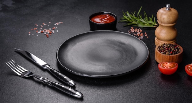 Empty round black plate on dark moody black background with copy space