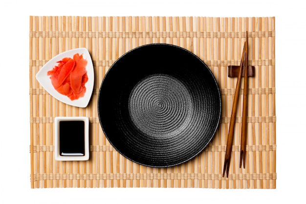 Empty round black plate with chopsticks 