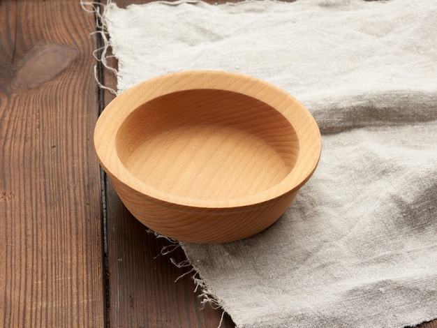 Empty round brown plate standing on a gray linen napkin