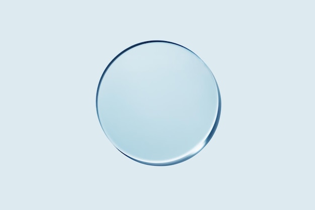 Empty round petri dish or glass slide on blue background Mockup for cosmetic or scientific product sample