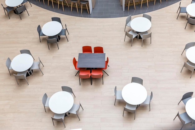 Empty round tables and chairs at a food court in a shopping mall View from above