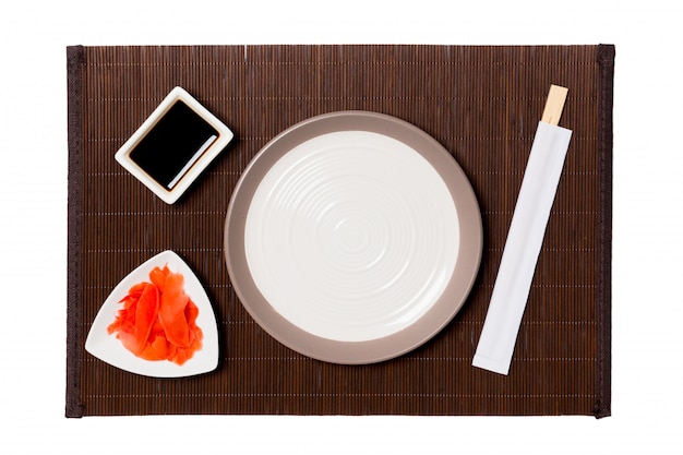 Empty round white plate with chopsticks for sushi