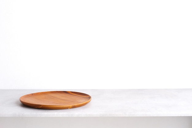 Empty round wooden plate on gray cement table background