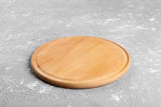 Empty round wooden plate on textured table. Wood plate for food or vegetable serving to customers