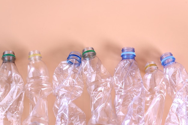 Empty rumpled used plastic bottle on pastel background. Pollution, environmental protection concept.