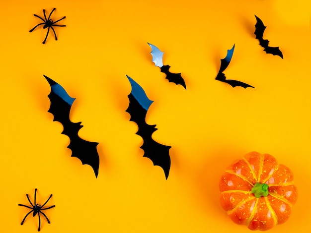 Empty rustic table in front of spider web background, orange background with bats and cobwebs, Halloween 