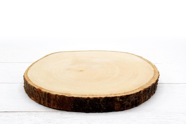 Empty rustic wooden slice serving board on white wooden table