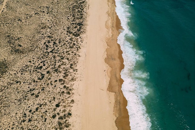 Empty sandy beach near wavy sea