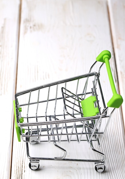 Empty shopping cart on a white wooden background