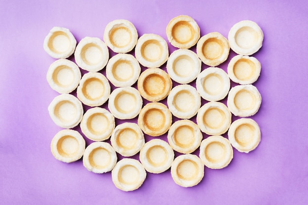 Empty shortbread tartlets laid out in a row.