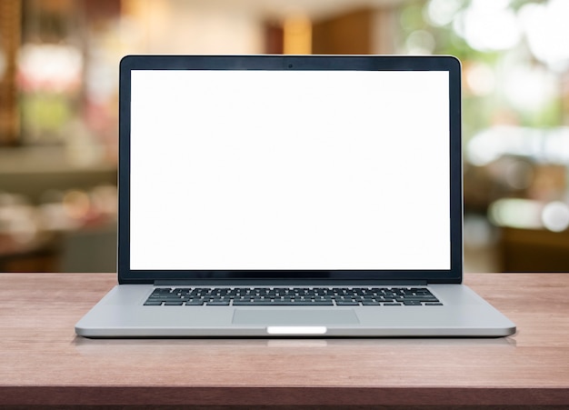 Empty space on wooden Desk with Laptop with blank white screen at coffee shop