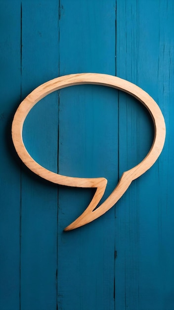 An empty speech bubble made with wooden letters on blue backdrop