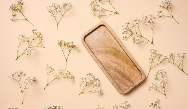 Empty square wooden plate on beige background top view