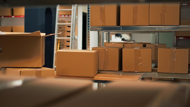 Empty storage space filled with stacks of merchandise and goods, shelves and racks of products in storehouse room. Warehouse used to deliver goods to customers working on logistics.