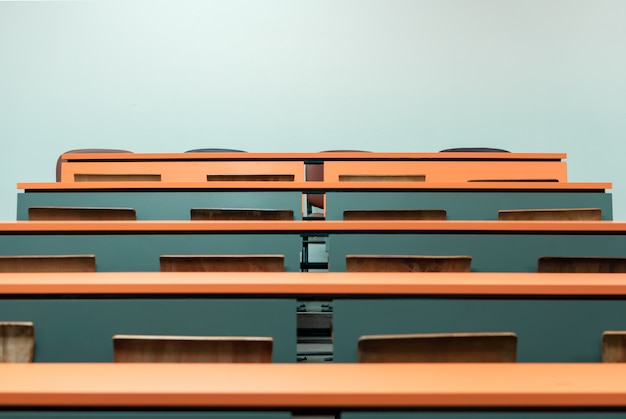 Empty student desk with wooden chair in the lecture classroom of college