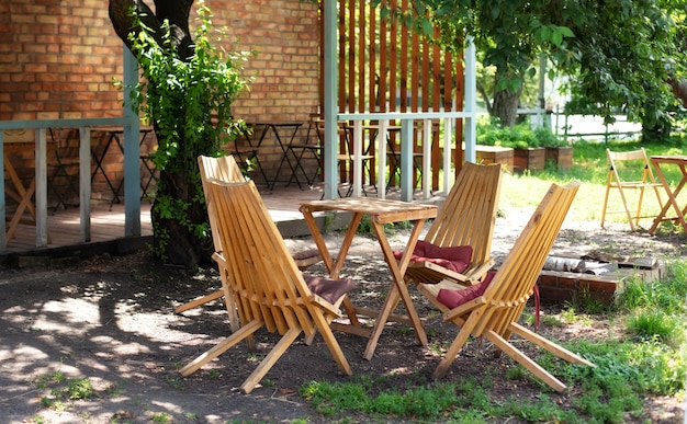 Empty sun loungers and table on veranda of house in forest. outdoor furniture for leisure time in nature.