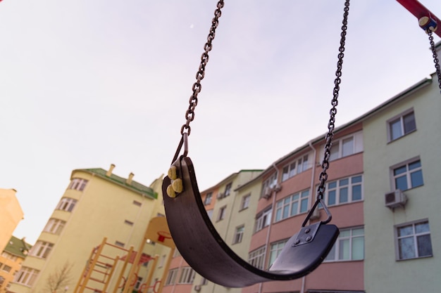 Empty swings on the playground in the courtyard of a residential building in Kyiv Ukraine