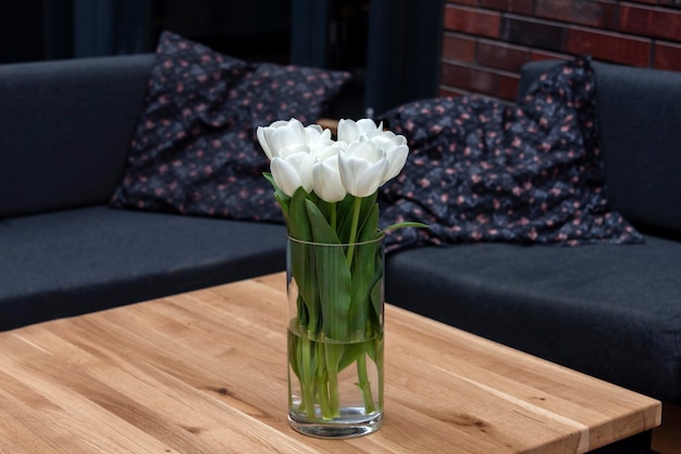 Empty table with flowers in outdoor cafe or restaurant Sidewalk cafe Touristic setting tulips on cafe table sidewalk cafe furniture