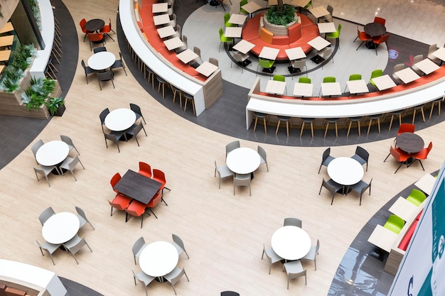 Empty tables in the cafe at the food court in the mall Place for meetings and entertainment Top view