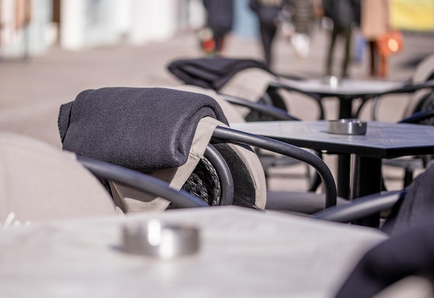 Empty tables outside between lunch hours along a cobblestone alley in a European city a veranda a cafe