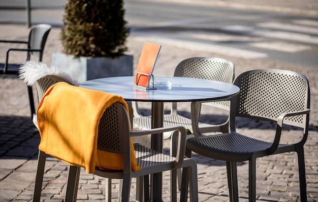 Empty tables outside between lunch hours along a cobblestone alley in a European city a veranda a cafe