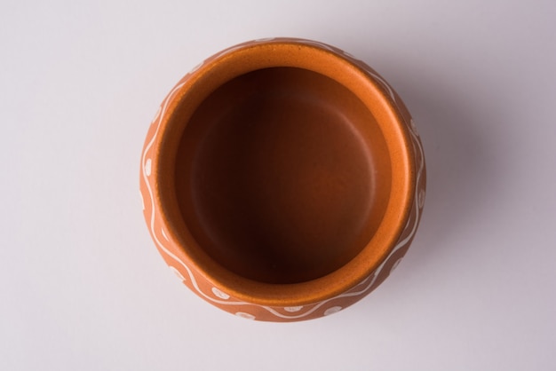 Empty terracotta dinnerware or dining set like plate, soup bowl, serving bowl, glass made up of brown clay, isolated over white