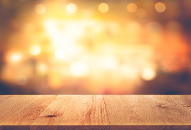 Empty the top of wooden deck table with  blurred light gold abstract background.for product display