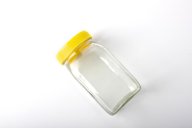 Empty transparent glass jar with yellow cap