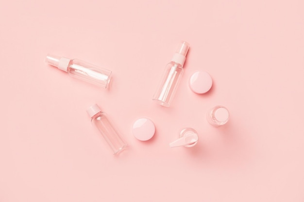 Empty tubes for cosmetics on a pastel pink background. Flat lay, top view. Banner.