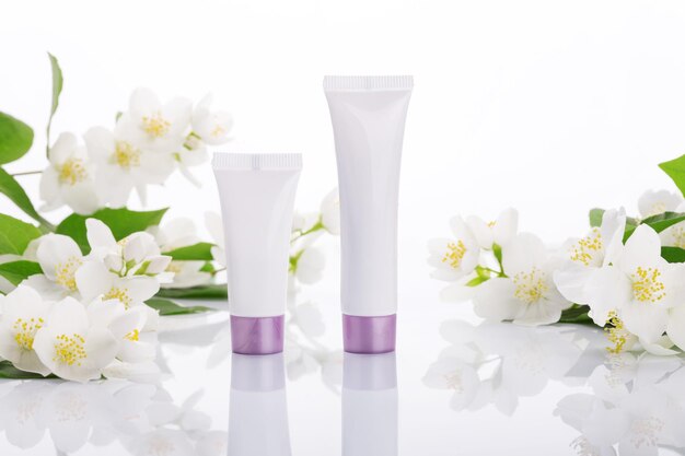 Empty tubes of cream on a white background with flowers