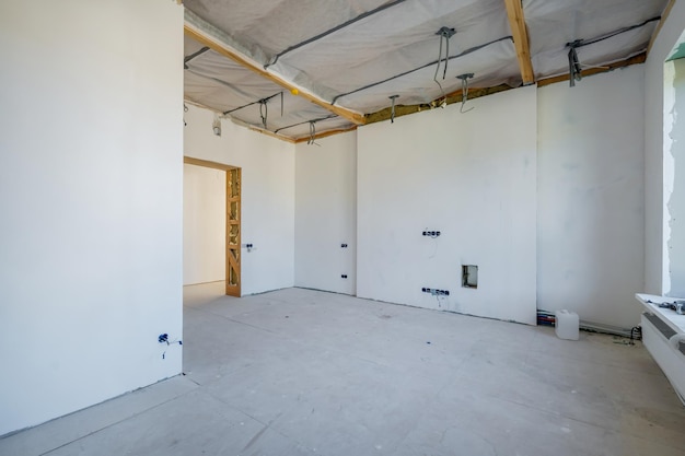 Empty unfurnished room with minimal preparatory repairs interior with white walls and drywall