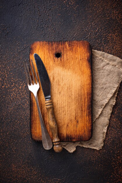 Photo empty vintage cutting board with fork and knife