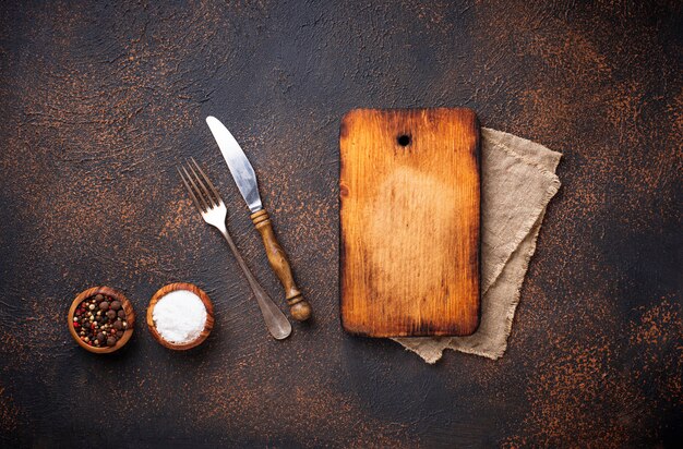 Photo empty vintage cutting board with spices and cutlery