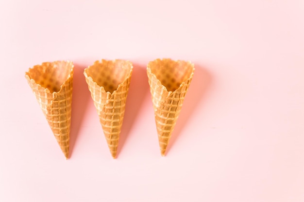 Empty waffle ice cream cones on a pink background.