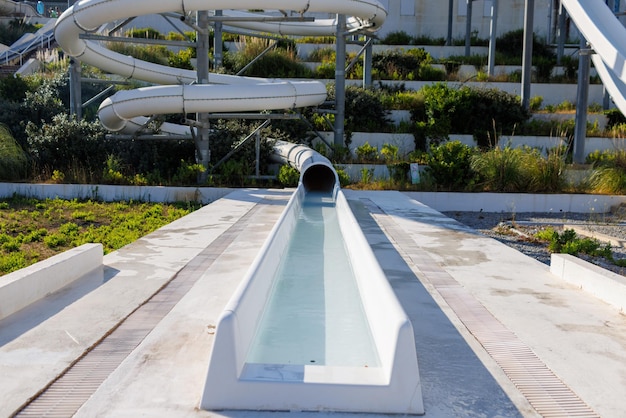 Empty water park with high white slides and white sun loungers