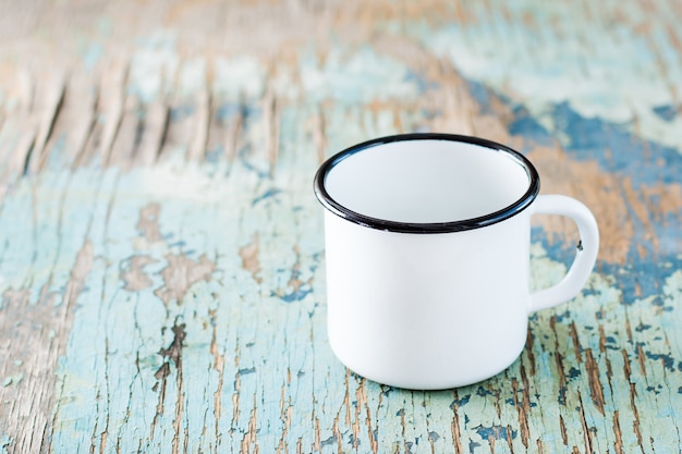 Empty white enameled mug for camping and travel