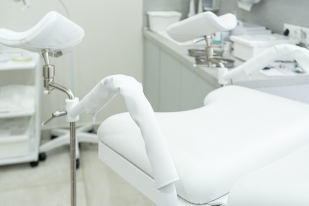 Empty white gynecological chair in modern medical center