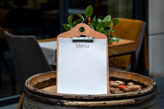 Empty white paper menu on restaurant entrance Modern and cozy cafe or bar facade with tables and chairs on outdoor patio