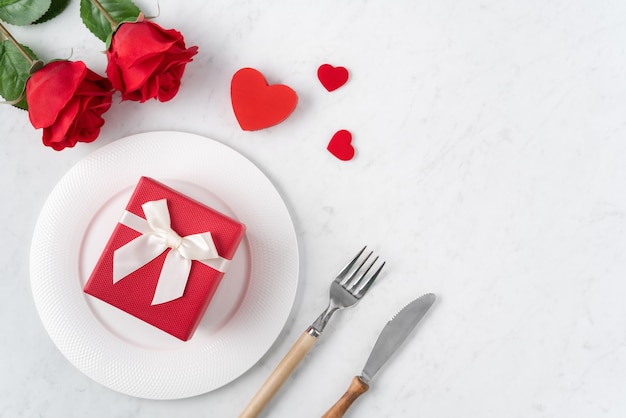 Empty white plate with tableware for Valentine's Day special holiday dating meal concept.