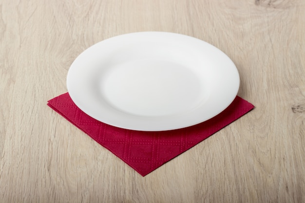 Empty white plate on wooden table