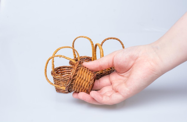 Empty wicker baskets in hand on a white background