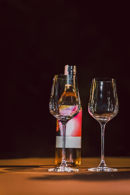 Empty wine glasses and bottle of wine on table