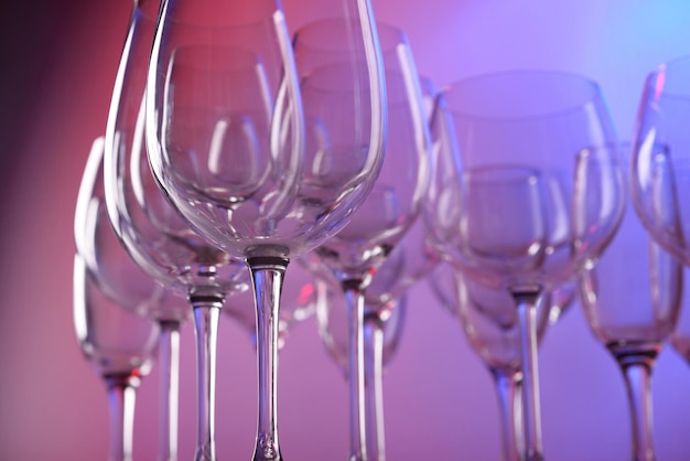 Empty wine glasses on color background