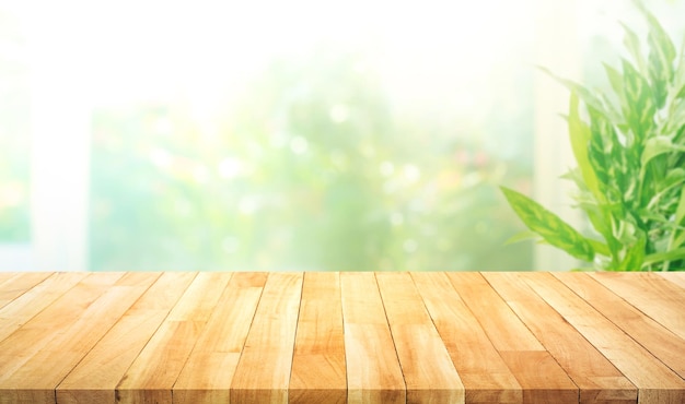 Empty wood table top on blur abstract green garden from window kitchen in the morning