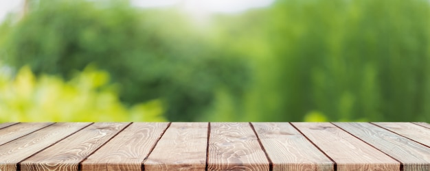 Empty wood table top and blurred green tree and vegetable in agricultural farms. background.