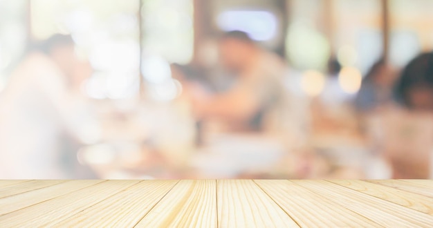 Empty Wood table top with Restaurant cafe or coffee shop interior with customer blur vintage style