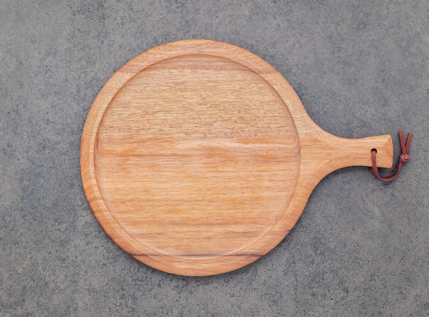 Empty wooden pizza platter set up on dark stone background Pizza board on stone background flat lay and copy space