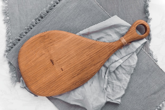 Empty wooden serving board on gray cloth background