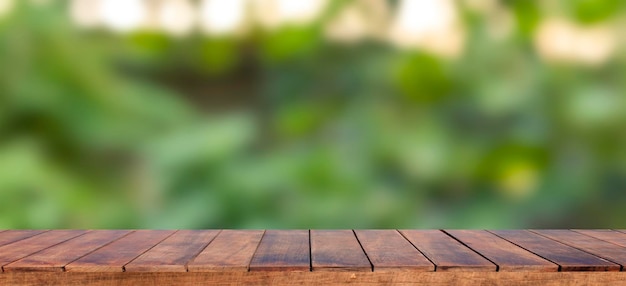 Empty wooden table background and blurry green background on the agricultural farm Background ideas can be used for displaying or editing your products